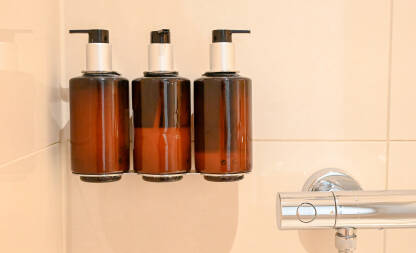 Tri bočice sa šamponom za kosu, regeneratorom i gelom za tuširanje u hotelu. Sredstva za ličnu higijenu. Kupka u bočici.