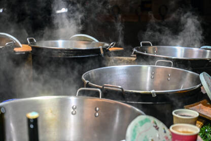 Veliki lonci s toplim kuhanim vinom i čajem na božićnom sajmu. Veliki lonci za kuhanje s toplim napitcima.