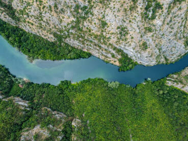 Kanjon Matka, Sjeverna Makedonija. Duboki kanjon rijeke između planina, snimak dronom. Kanjon Matka, Sjeverna Makedonija. Turistički brodić plovi rijekom.