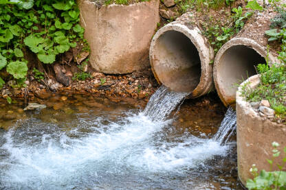 Ispuštenje otpadnih voda u rijeku. Zagađena voda se ispušta iz cijevi u rijeku.