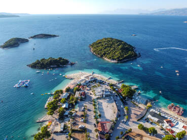 Egzotične plaže i prekrasni otoci ljeti. Jonsko more u Ksamilu, Albanija, snimak dronom. Primorsko ljetovalište i hoteli. Obala.