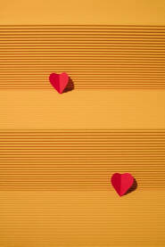 Crvena srca od papira na žutoj pozadini.