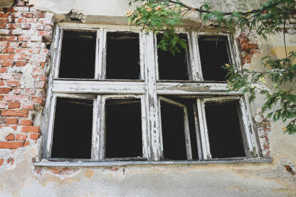 Razbijeni prozori na kući. Oštećena kuća kao posljedica rata. Kuća u ruševinama.