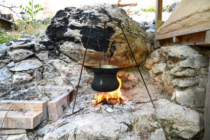 Bakreni lonac na vatri. Kuhanje ručka u bakarnom kotliću na plamenu.