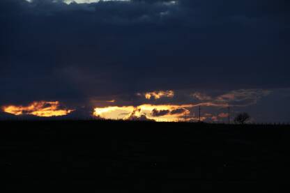 Oblacno vreme, yraci sunca vidljivi kroz oblake, tamnija fotografija