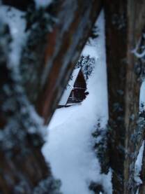 Bungalov prekriven snijegom u Nacionalnom parku Kozara, slikan kroz ogradu.