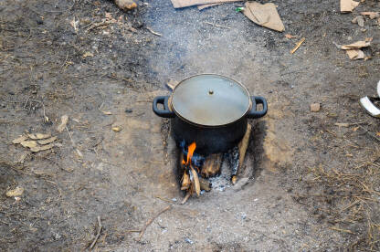 Lonac na vatri. Pripremanje i kuhanje hrane u prirodi. Kampiranje u šumi. Lonac s juhom na otvorenoj vatri.