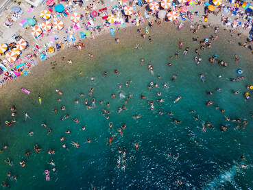 Veliki broj turista na plaži tokom ljeta. Ljudi se sunčaju na plaži i kupaju u moru. Neum, Bosna i Hercegovina, snimci dronom.