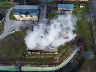 Fabrički dimnjak ispušta zagađenje u životnu sredinu. Snimak dronom na industrijski kompleks. Zagađenje zraka iz dimnjaka. Toksičan dim iz dimnjaka u industrijskoj zoni.
