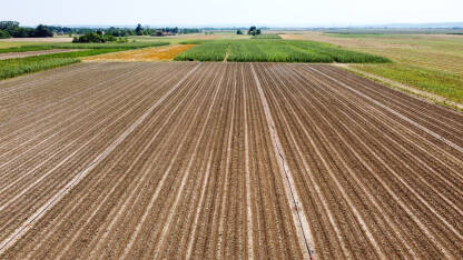 Snimak dronom polja tokom ljeta. Oranice blizu sela. Uzorana njiva.