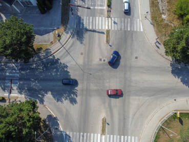 Vozila se kreću kroz raskrsnicu. Snimak dronom automobila koji prolaze kroz gradsku raskrsnicu.