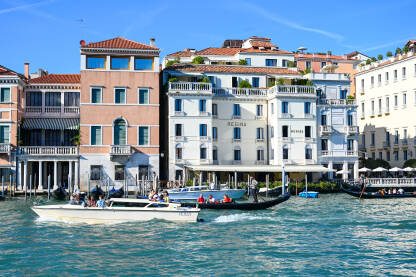 Venecija, Italija: Historijske građevine uz riječni kanal. Čamci na vodi. Popularno turističko odredište.
