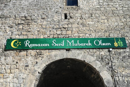 Natpis na baneru: Ramadan Serif Mubarek Olsun. Natpis na zgradi. Ramazanske čestitke. Mjesec Ramazana.
