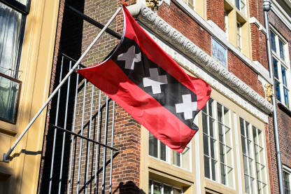 Zastava Amsterdama na zgradi u centru grada. Nizotemska.