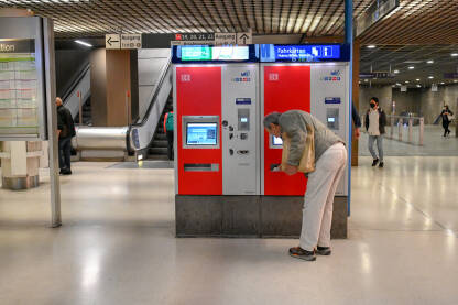 Čovjek kupuje kartu za voz na aparatu na željezničkoj stanici. Putnik unutar podzemne željezničke stanice. Prijevoz.