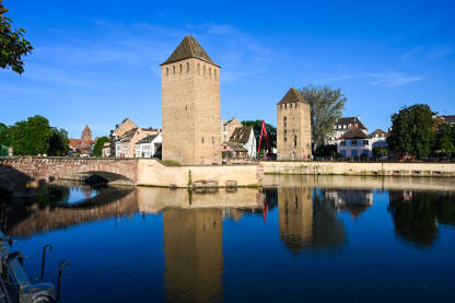 Strasbourg, Francuska: Srednjovjekovne kule i most preko rijeke tokom zalaska sunca. Ponts couvert.