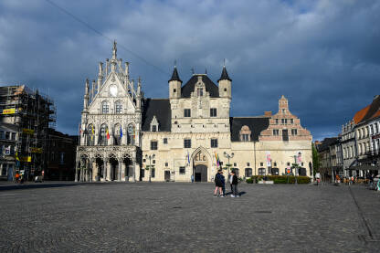 Mechelen, Belgija: Zgrada gradske vijećnice na glavnom trgu u centru grada. Ljudi šetaju u gradu.
