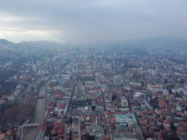 Veoma zagađen zrak iznad Sarajeva zimi. Panoramski pogled. Veliko zagađenje zraka u centru grada, snimak iz zraka dronom. Smog.