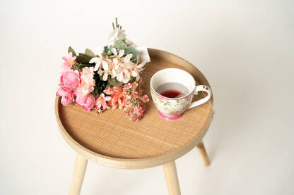 Čaj i cvijeće na drvenom stolu