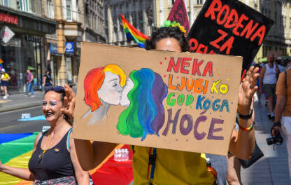 Povorka ponosa 2022, Sarajevo, Bosna i Hercegovina. Djevojka drži natpis "Neka ljubi ko god koga hoće".