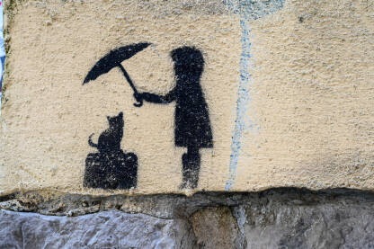 Simbol djevojčice koja drži kišobran iznad mačke. Grafit na zidu. Zaštita životinja.