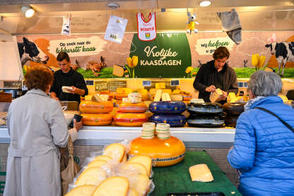 Prodaja sira na lokalnoj pijaci u Nizozemskoj. Trgovci prodaju sir. Ljudi kupuju sir na lokalnoj tržnici.
