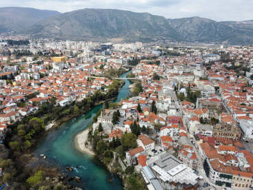 Panorama Mostara, BiH. Rijeka Neretva protiče kroz grad. Snimak dronom kuća i zgrada u Mostaru.