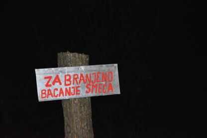 Znak za zabranjeno bacanje smeća postavljen na posječeno drvo.
