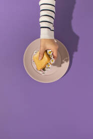Zenska ruka drži tost sendvič s cvijećem tratinčice.