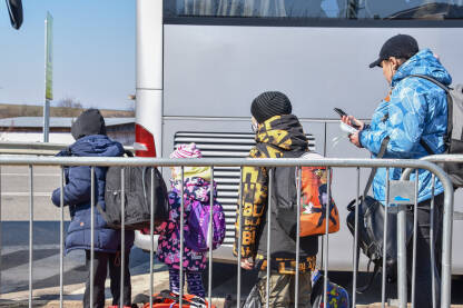 Majka sa djecom čeka prevoz na granici Ukrajina-Slovačka. Izbjeglice iz Ukrajine putuju dalje u Evropu.