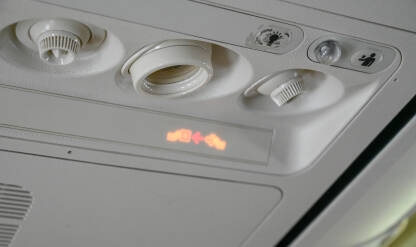 Putnička kontrolna jedinica u avionu. Ventilacijski otvori i razna kontrolna dugmad i indikatorska svjetla. Osvijetljeni simboli označavaju potrebu za vezivanjem sigurnosnih pojaseva i zabranu pušenja