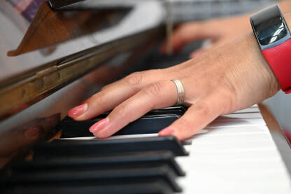 Žena svira piano u crkvi. Krupni plan ruku muzičare koja svira klavir u katedrali. Religijska muzika.