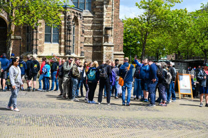 Delftu, Nizozemska: Grupa turista na trgu u gradu. Turisti istražuju i razgledavaju grad.