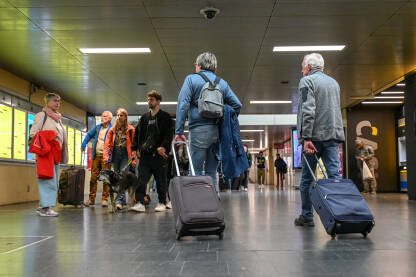 Putnici s prtljagom na željezničkoj stanici. Prijevoz. Ljudi putuju. Grupa turista sa torbama i koferima.