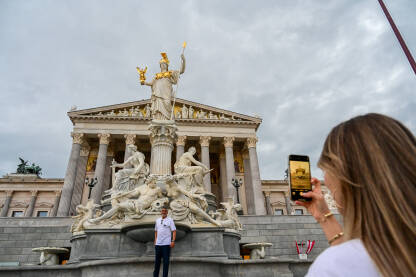 Beč, Austrija: Zgrada Parlamenta. Fontana Palas Atene. Turisti se fotografišu ispred austrijskog parlamenta.