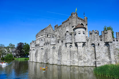 Gent, Belgija: Dvorac uz rijeku u centru grada. Turisti na čamcima na rijeci.