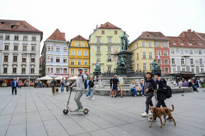 Graz, Austrija: Grupa ljudi na glavnom trgu u centru grada. Historijske zgrade na glavnom trgu ili Hauptplatzu. Stari grad Graz. Erzherzog-Johann-Brunnen fontana.