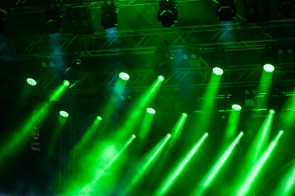 Zelena svjetla na bini tokom koncerta. Svjetla i dim na bini tokom muzičkog festivala. Reflektori i svjetla.