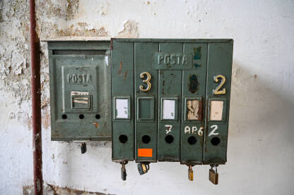 Stari poštanski sandučići u zgradi. Zahrđali poštanski sandučići na zidu.