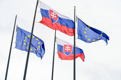 Zastave Slovačke i Evropske unije ispred parlamenta u Bratislavi.Zastave Slovačke Republike i EU na jarbolu. Državni grb Slovačke.