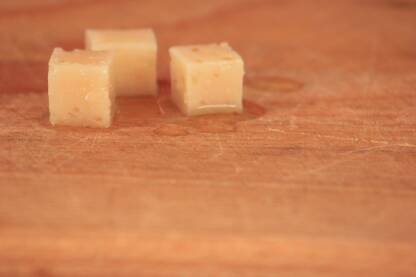 Sir u ulju na drvenoj plati. Kockice sira kroz na drvenoj plati.