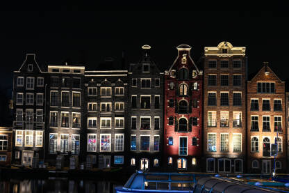 Amsterdam, Nizozemska. Popularne zgrade u gradu Amsterdamu noću. Tipične holandske kuće sa šarenim fasadama. Holandija