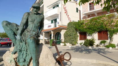 Spomenik ribaru nepoznatog autora. Nalazi se pored šetačke zone uz pristanište u Podgori grada u Hrvatskoj.