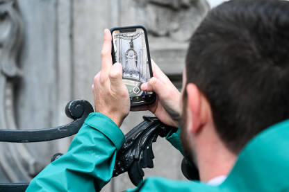 Bruxelles, Belgija. Turist fotografira Maneken Pis, simbol Brisela. Poznata znamenitost, skulptura od bronzane fontane u centru grada.