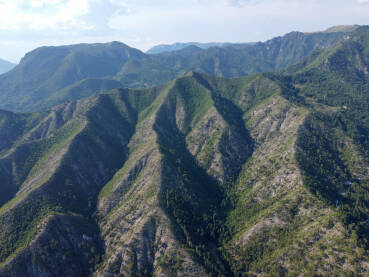 Snimak dronom visokih planina prekrivenih šumom. Planinski masiv. Planinski lanac iz zračne perspektive. Kanjon rijeke Neretve, Bosna i Hercegovina.