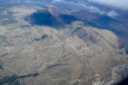 Pogled na planine kroz prozor aviona. Putovanje avionom. Planina Vlašić iz zraka.
