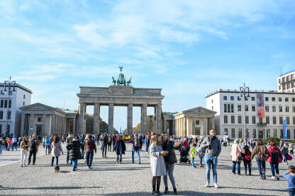 Berlin, Njemačka. Grupa turista ispred Brandenburške kapije. Popularna turistička destinacija.