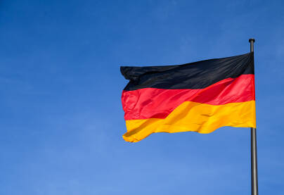 Njemačka zastava se vijori na vjetru.  Crna, crvena i žuta boja na njemačkoj zastavi ispred Bundestaga. Simbol njemačkog naroda.