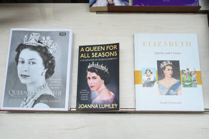 Kraljica Elizabeta na naslovnici knjige. Izložene knjige na policama. Knjige na prodaju u knjižari.