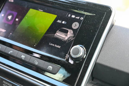 Infotainment sistem sa ekranom osjetljivim na dodir u modernom automobilu koji prikazuje sigurnosni meni Lane Assist. Moderni ekran na instrument tabli vozila koji prikazuje postavke pomoći vozaču.
